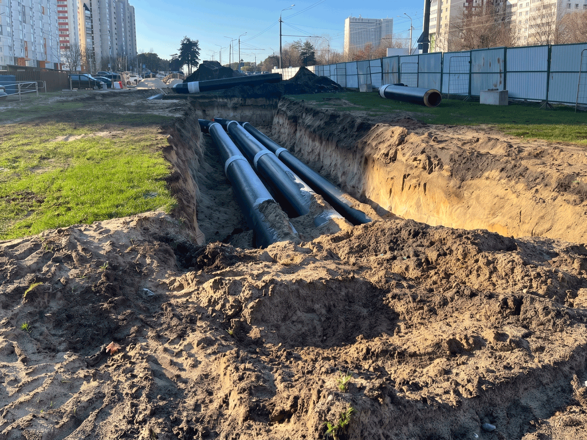 Pipes laid in excavated trench at construction site